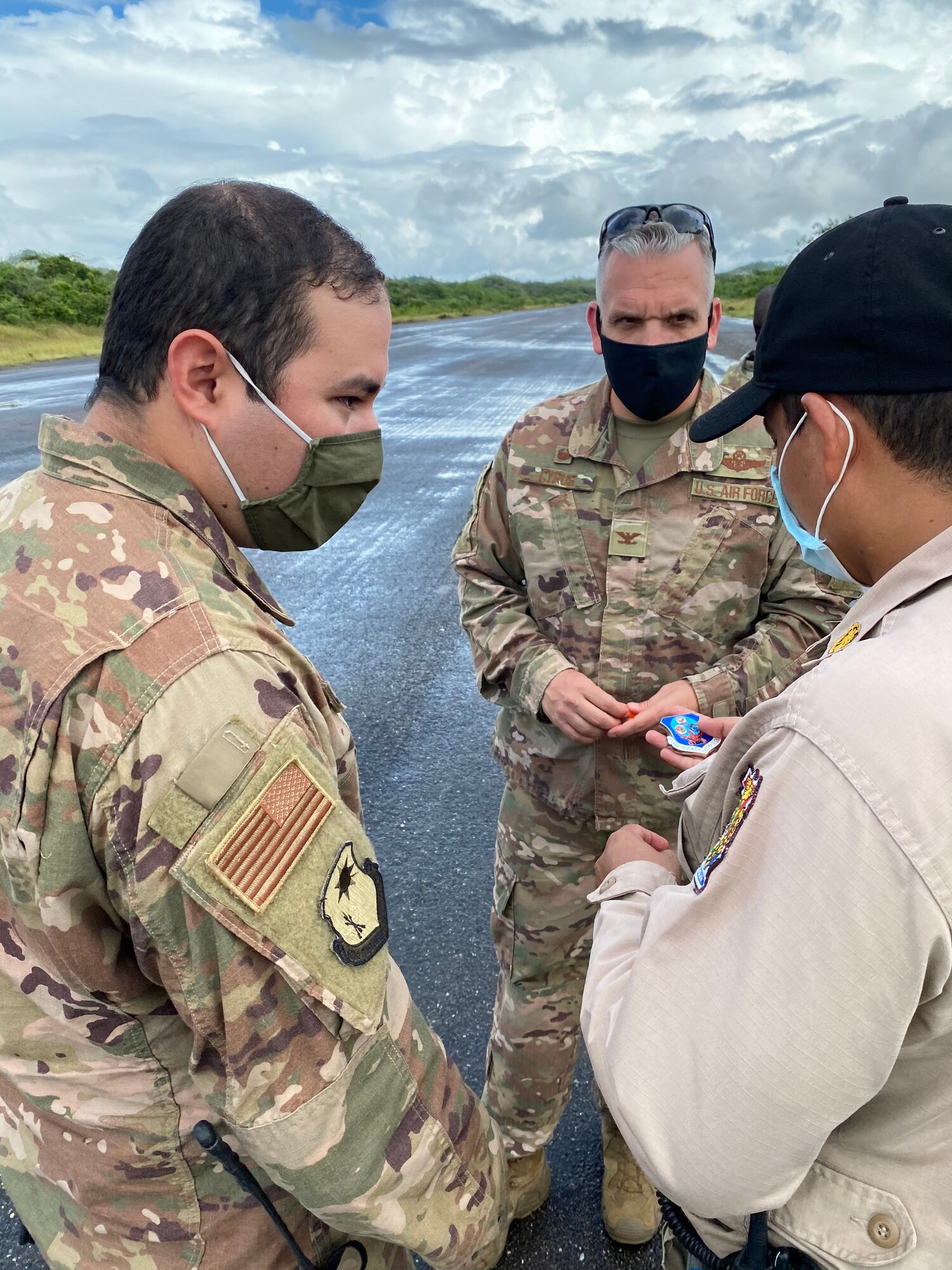 U.S. Air Force Tech. Sgt. Luis Barrios, 621st Contingency Response Squadron airfield manager, left, translates as U.S. Air Force Col. Gregory Cyrus, 621st Contingency Response Group commander, presents a Honduran official with his commander’s coin for helping clear debris at Aguacate landing zone in Catacamas, Honduras, Nov. 25, 2020. Fourteen members from the 621st Contingency Response Wing were deployed to Honduras to support disaster relief efforts in the aftermath of Hurricane Iota. (U.S. Air Force photo)