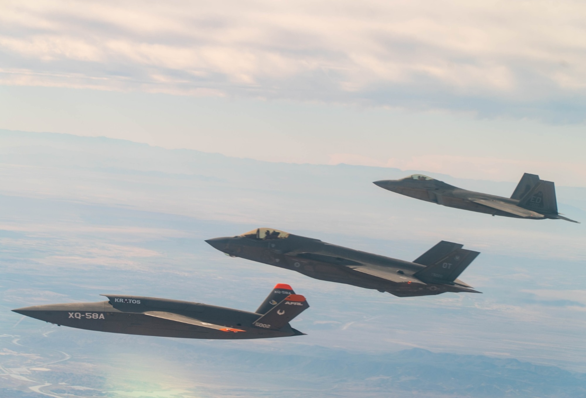 A U.S. Air Force F-22 Raptor and F-35A Lightning II fly in formation with the XQ-58A Valkyrie low-cost unmanned aerial vehicle over the U.S. Army Yuma Proving Ground testing range, Ariz., during a series of tests Dec. 9, 2020. This integrated test follows a series of gatewayONE ground tests that began during the inaugural Department of the Air Force on-ramp last year in December. (Courtesy photo)