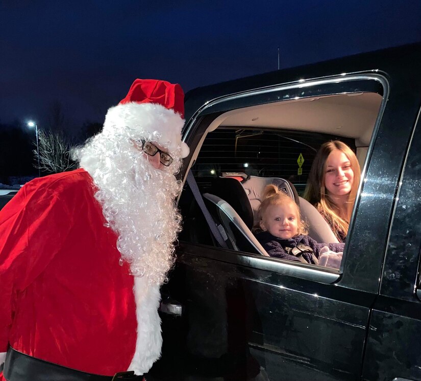 Santa Claus poses for a photo with a Pa. Guard family during Park & Presents, an event held Dec. 8-10 where children of deployed 28th ECAB Soldiers enjoyed a drive-thru style visit with Santa and received a bag of toys. (Courtesy Photo)