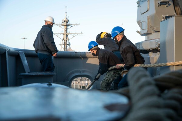 Sailors assigned to the Wasp-class amphibious assault ship USS Kearsarge (LHD 3) heave mooring line on the fantail Dec. 15, 2020.