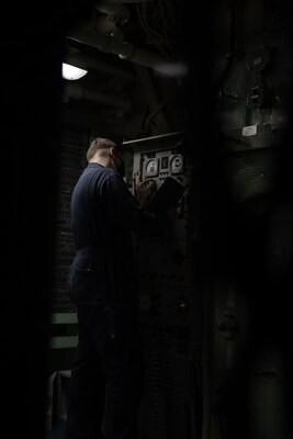 Electricians Mate 2nd Class Darrin Eaton, assigned to the Wasp-class amphibious assault ship USS Kearsarge (LHD 3), reports readings from a degaussing switchboard Dec. 15, 2020.