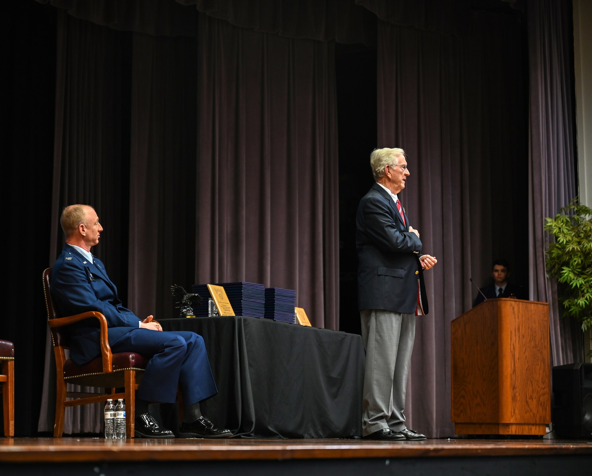 U.S. Air Force Retired Lt. Col. Richard “Gene” Smith, former Vietnam prisoner of war and former 50th Flying Training Wing commander, speaks to Specialized Undergraduate Pilot Training Class 21-03 while U.S. Air Force Col. Seth Graham, 14th Flying Training Wing commander, listens on Dec. 11, 2020, at Columbus Air Force Base, Miss. Smith was held captive for over five years in the infamous Hoa Lo Prison, during the Vietnam War. (U.S. Air Force photo by Airman 1st Class Jessica Williams)