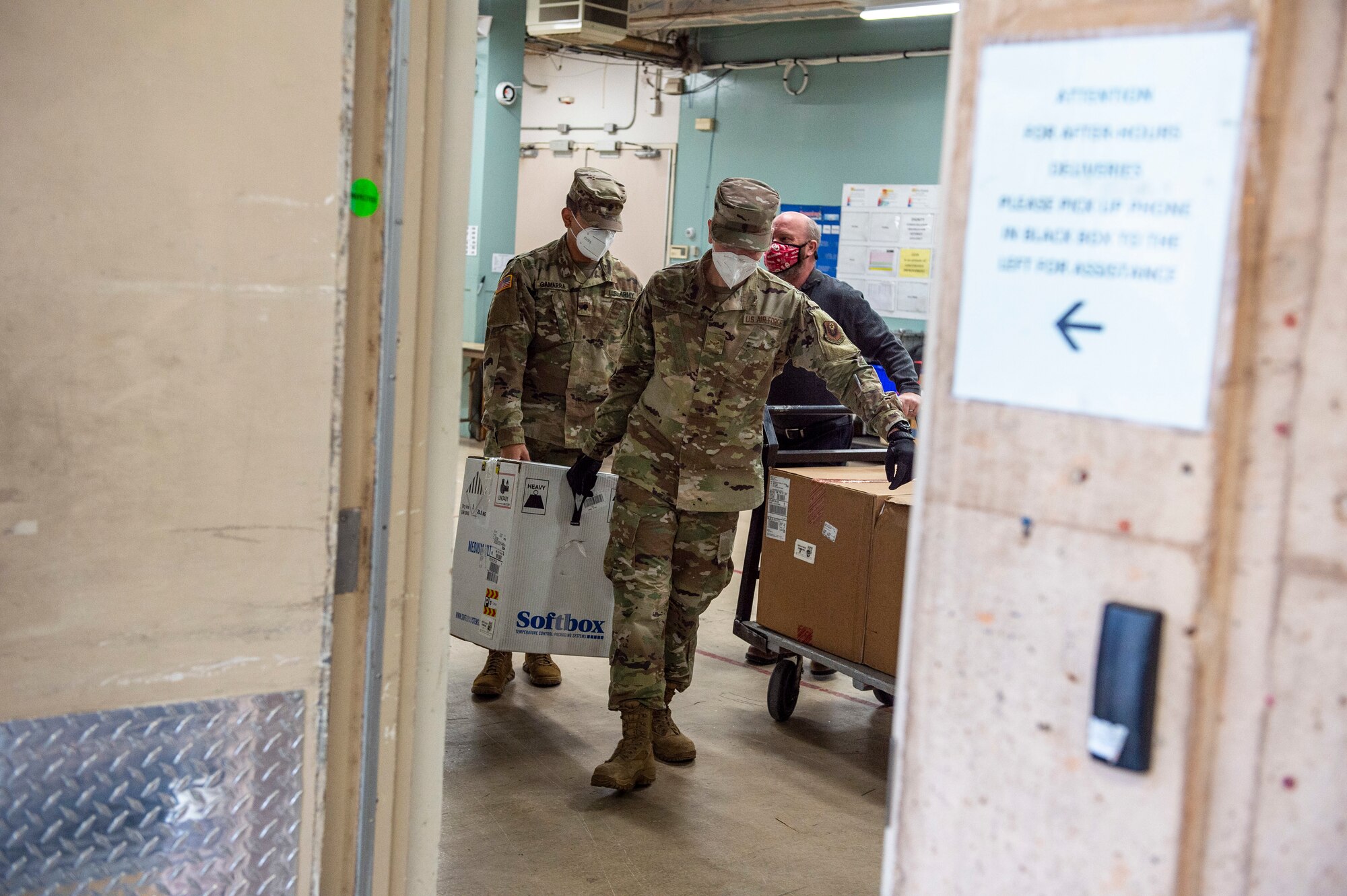 Spc. Martin Gamarra (left) and Airman 1st Class Andreas Owen (right) carry a box containing COVID-19 vaccinations after making their first delivery at a hospital in Oklahoma City, Dec. 15, 2020.

Gamarra and Owen are part of a larger team of Guardsmen who are delivering vaccines from from one of five centralized hubs supporting 11 satellite locations across Oklahoma. The Guardsmen will be using Oklahoma State Department of Health vehicles to transport the vaccines to the satellite locations with an escort from the Oklahoma Highway Patrol. (Oklahoma National Guard photo by Anthony Jones)