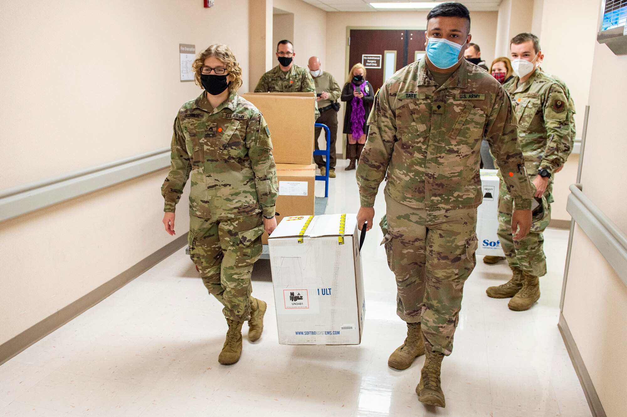 Cpl. Danielle O'Connor and Spc. Ryan Tate (right) quickly move boxes containing COVID-19 vaccinations to vehicles the Guard members will use to transport the vaccines to sites across the state, Dec. 15, 2020.

These are the first two boxes of vaccines to be distributed from one of five centralized hubs supporting 11 satellite locations across Oklahoma. The Guardsmen will be using Oklahoma State Department of Health vehicles to transport the vaccines to the satellite locations with an escort from the Oklahoma Highway Patrol. (Oklahoma National Guard photo by Anthony Jones)