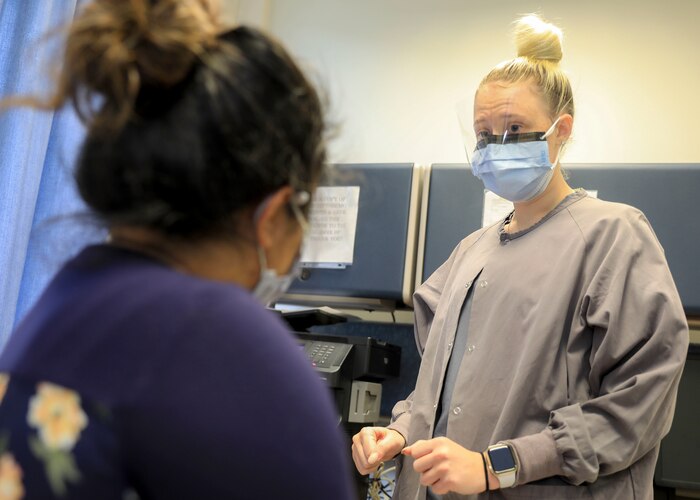 Image of an Airman talking to a patient
