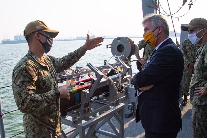 201215-N-IO414-1033 NAVAL SUPPORT ACTIVITY BAHRAIN (Dec. 15, 2020) Mineman 2nd Class Tommy Dao speaks with Secretary of the Navy Kenneth J. Braithwaite about the capabilities of the mine countermeasure ship USS Devastator (MCM 6) during his visit with personnel on board U.S. Naval Support Activity Bahrain, Dec. 15. Devastator is deployed to the U.S. 5th Fleet area of operations in support of naval operations to ensure maritime stability in the Central Region, connecting the Mediterranean and Pacific through the Western Indian Ocean and three critical chokepoints to the free flow of global commerce.