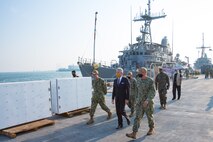 201215-N-IO414-1097 NAVAL SUPPORT ACTIVITY BAHRAIN (Dec. 15, 2020) Capt. Michael Brasseur, right, deputy commander of Commander, Task force (CTF) 55, speaks with Secretary of the Navy Kenneth J. Braithwaite, center, during his visit with personnel on board U.S. Naval Support Activity Bahrain, Dec. 15. CTF 55 commands surface forces such as U.S. Navy patrol craft, U.S. Coast Guard patrol boats and independently deployed ships in U.S. 5th Fleet area of operations in support of naval operations to ensure maritime stability in the Central Region.