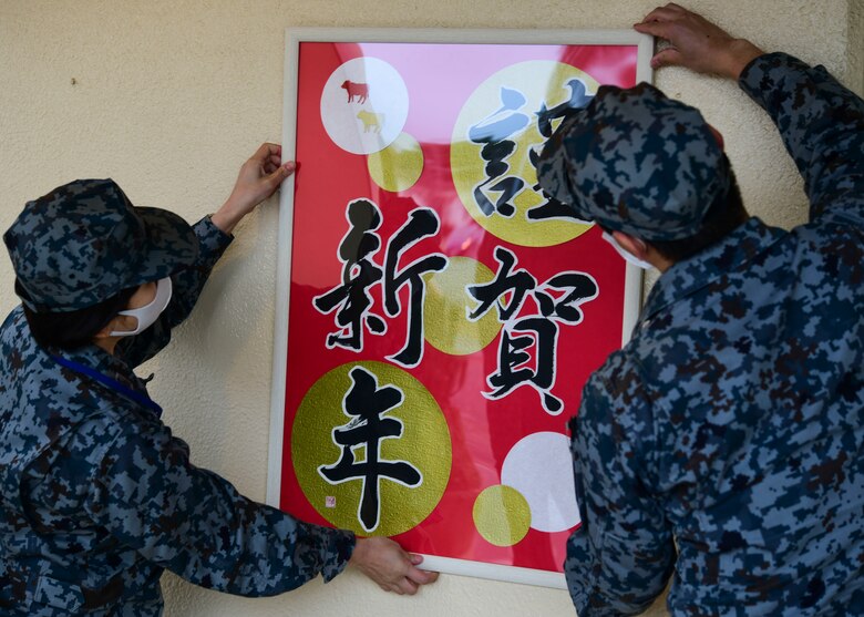 Japanese Airmen hang Japanese calligraphy photo.