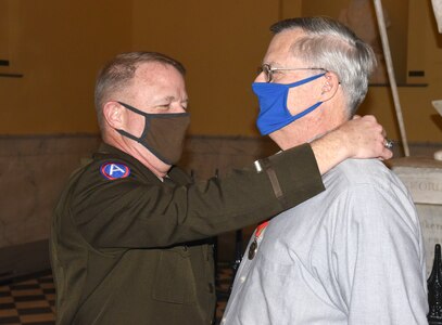 Maj. Gen. Timothy P. Williams, the Adjutant General of Virginia, presents the Ancient Order of St. Barbara to retired Col. Mike Coleman during a ceremony at the Capitol of Virginia Dec. 14, 2020, in Richmond, Virginia.