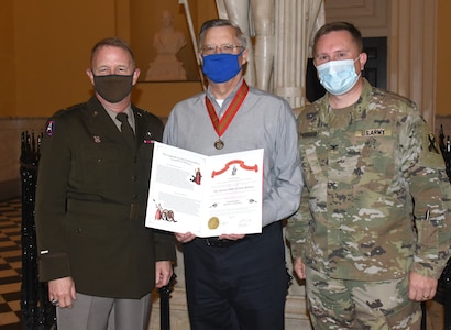 Maj. Gen. Timothy P. Williams, the Adjutant General of Virginia, presents the Ancient Order of St. Barbara to retired Col. Mike Coleman during a ceremony at the Capitol of Virginia Dec. 14, 2020, in Richmond, Virginia.