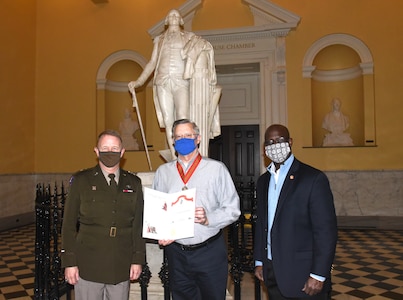 Maj. Gen. Timothy P. Williams, the Adjutant General of Virginia, presents the Ancient Order of St. Barbara to retired Col. Mike Coleman during a ceremony at the Capitol of Virginia Dec. 14, 2020, in Richmond, Virginia.