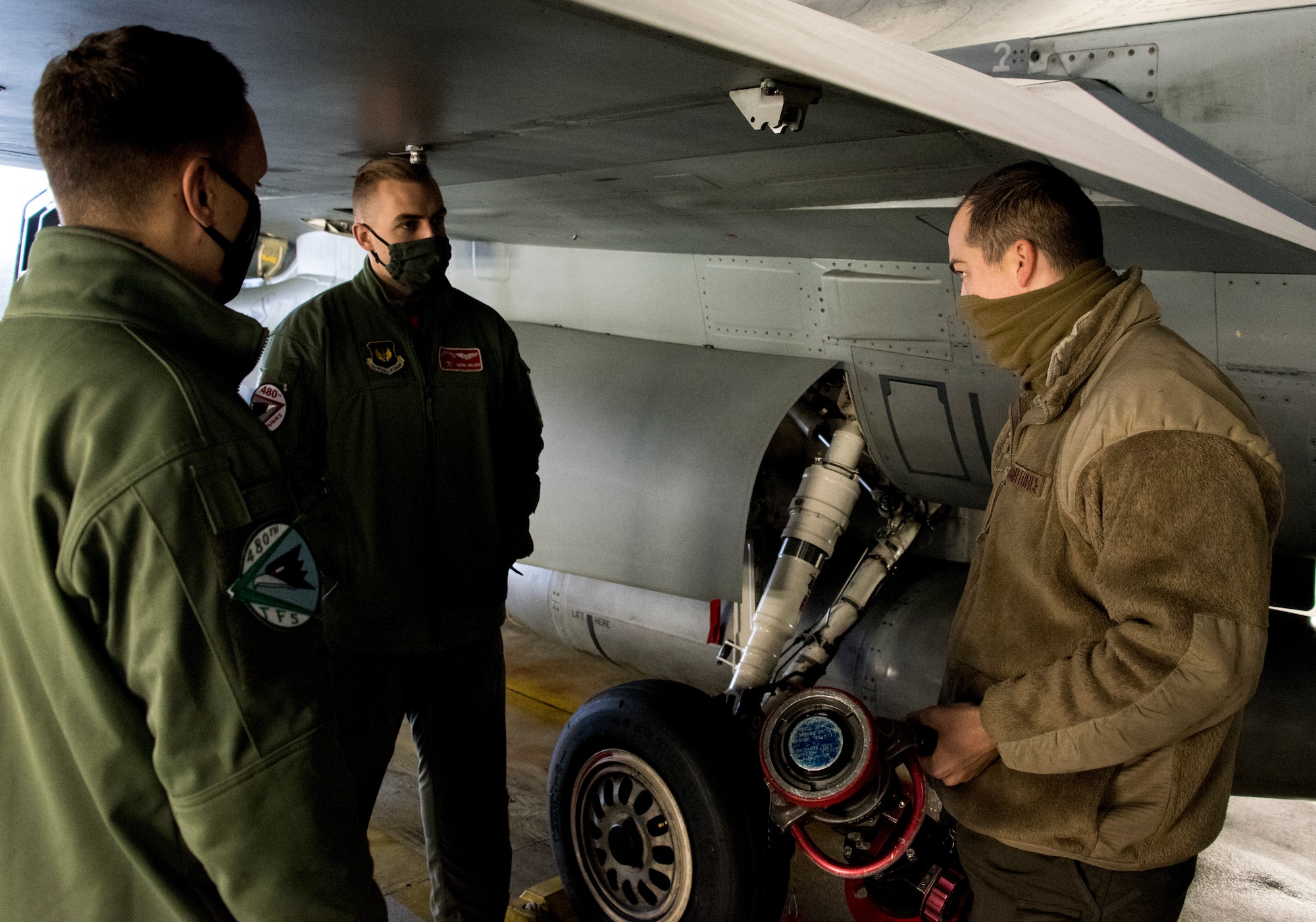 U.S. Air Force Senior Airman Ryan Versen, 52nd Aircraft Maintenance Squadron assistant dedicated crew chief, right, teaches pilots how to refuel an F-16 Fighting Falcon at
Spangdahlem Air Base, Germany, Dec. 11, 2020. The training provided experience for pilots to
refuel their own jet in a deployed environment. (U.S. Air Force photo by Senior Airman Chance D. Nardone)