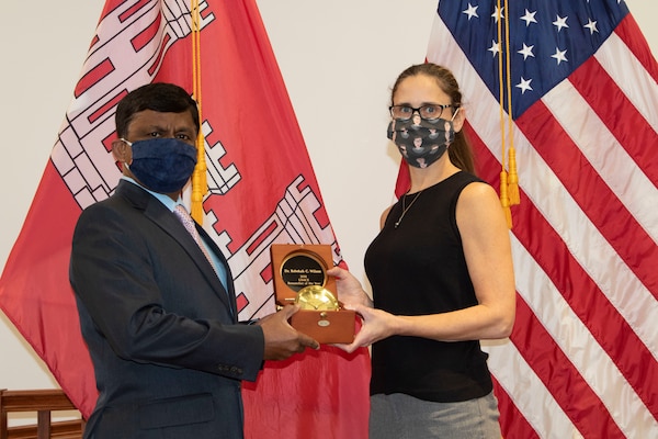The U.S. Army Engineer Research and Development Center’s, Construction Engineering Research Laboratory (CERL), acting director, Kirankumar Topudurti (left), hands Dr. Rebekah Wilson (right),  United States Army Corps of Engineers’s (USACE) Paint Technology Technical Center of Expertise leader, the USACE Researcher of the Year Award at the CERL campus, Champaign, Ill., Nov. 12, 2020. Wilson was recognized for her expertise and achievements in the research and development of advanced coatings.