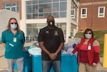 Domon Barr stands with two Lebanon VA Medical Center employees while dropping off donations for the Lebanon VA facility.