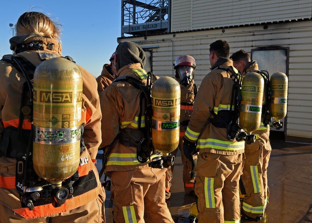 U.S. Air Force Tech. Sgt. Phillip Crews 312th Training Squadron fire protection instructor, addresses his class during a break in their grade level interior fire training exercise at the Louis F. Garland Department of Defense Fire Academy on Goodfellow Air Force Base, Texas, Dec. 10, 2020. Crews reiterated the importance of safety, administrating strong communication, and utilizing the buddy system while combating dangerous scenarios, much like the students will during their operational service and deployments. (U.S. Air Force Senior Airman Abbey Rieves)