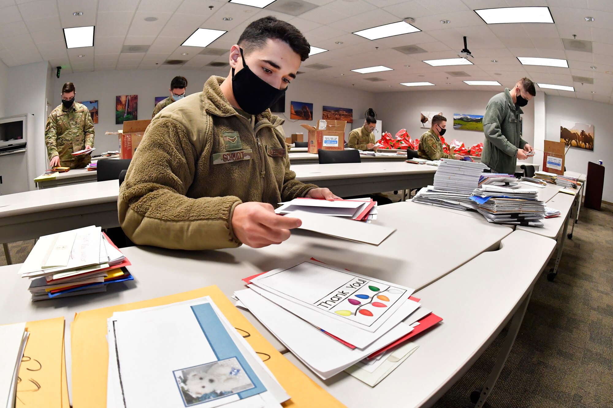 An Airman sorts holiday cards on a table.