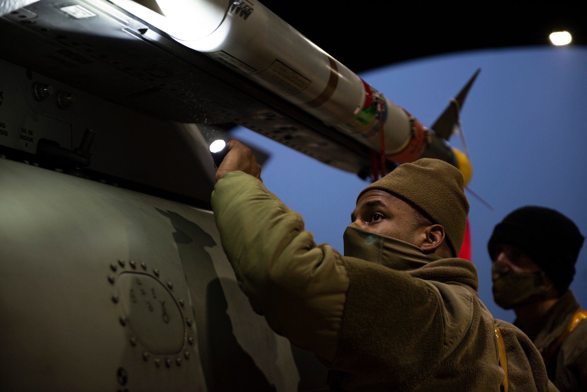 U.S. Air Force Staff Sgt. Shelton Thigpen, 748th Aircraft Maintenance Squadron weapons team chief, inspects a NATM-9M missile after loading it to the aircraft at Royal Air Force Lakenheath, England, Dec. 8, 2020. Airmen from the 48th MUNS converted the AIM-9M missiles to NATM-9M, or Special Air Training Missiles, for employment from the F-15 aircraft. (U.S. Air Force photo by Airman 1st Class Jessi Monte)