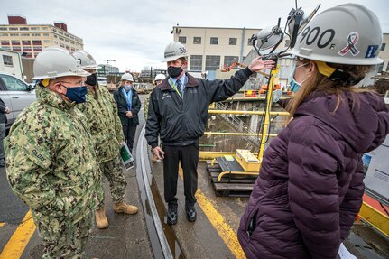 Chief of Naval Operations Adm. Mike Gilday is briefed by Sean Swansboro, Inactive Fleet, Reactor Compartment Disposal (RCD) and Recycling Program manager, and Amy O'Malia, Production Facilities and Plant Equipment manager, on Shipyard Infrastructure Optimization Program upgrades, and RCD disposal, Dec. 16, 2020, at Dry dock 3, during Gilday’s tour of Puget Sound Naval Shipyard & Intermediate Maintenance Facility in Bremerton, Washington. (PSNS & IMF photo by Scott Hansen)