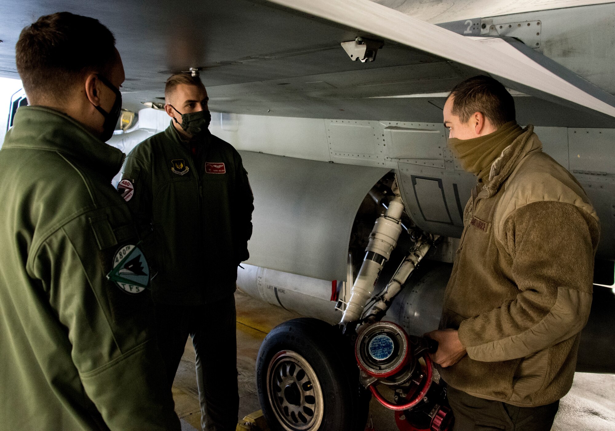 U.S. Air Force Senior Airman Ryan Versen, 52nd Aircraft Maintenance Squadron assistant dedicated crew chief, right, teaches pilots how to refuel an F-16 Fighting Falcon at
Spangdahlem Air Base, Germany, Dec. 11, 2020. The training provided experience for pilots to
refuel their own jet in a deployed environment. (U.S. Air Force photo by Senior Airman Chance D. Nardone)