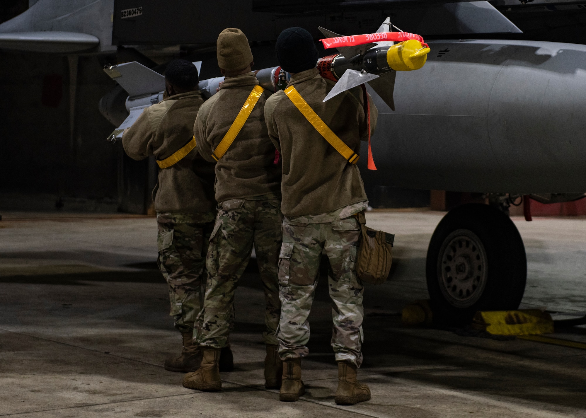 Airmen from the 48th Munitions Squadron prepare to load a NATM-9M missile onto an F-15C Eagle, assigned to the 493rd Fighter Squadron, at Royal Air Force Lakenheath, England, Dec. 8, 2020. Airmen from the 48th MUNS converted the AIM-9M missiles to NATM-9M, or Special Air Training Missiles, for employment from the F-15 aircraft. (U.S. Air Force photo by Airman 1st Class Jessi Monte)
