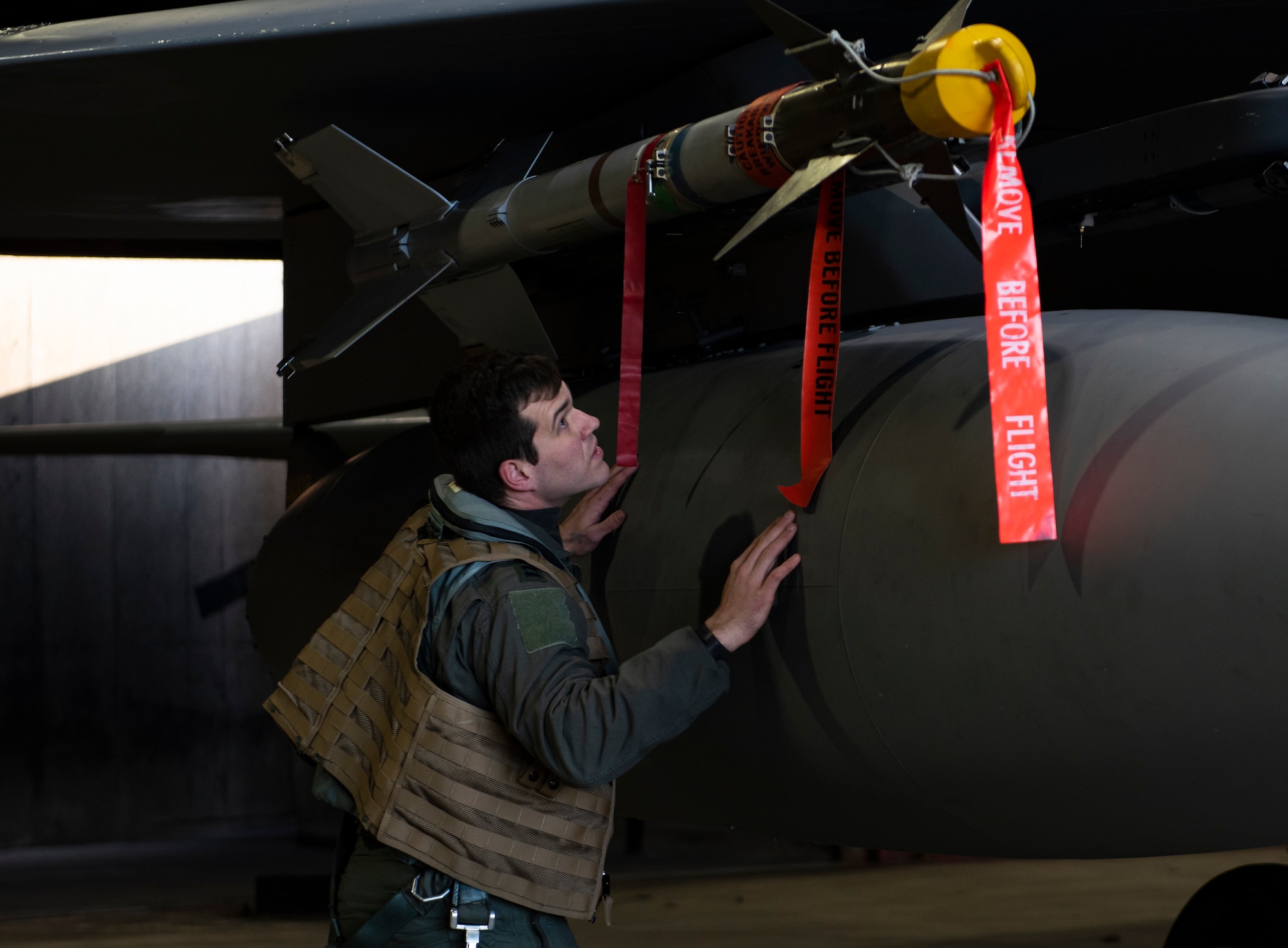 U.S. Air Force Capt. John Bynum, an electronic combat pilot assigned to the 493rd Fighter Squadron, inspects a NATM-9M missile during pre-flight checks at Royal Air Force Lakenheath, England, Dec. 8, 2020. 48th Fighter Wing pilots participated in a live missile fire exercise, gaining combat representative training that can't be fully imitated in a simulation during day-to-day training. (U.S. Air Force photo by Airman 1st Class Jessi Monte)