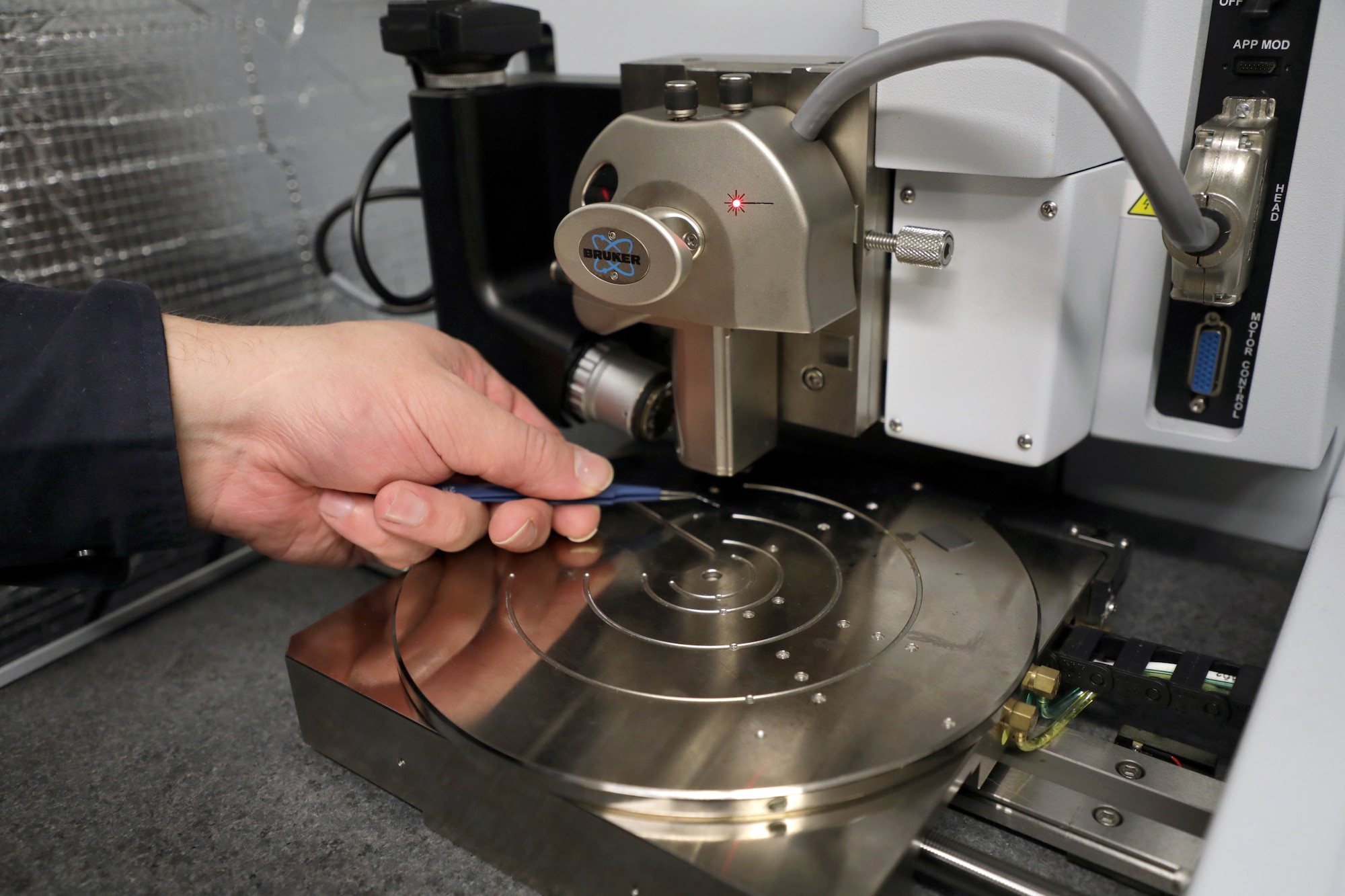 A sample is loaded into the Bruker Atomic Force Microscope system capable of performing nanoscale imaging experiments. (U.S. Air Force photo/Spencer Deer)