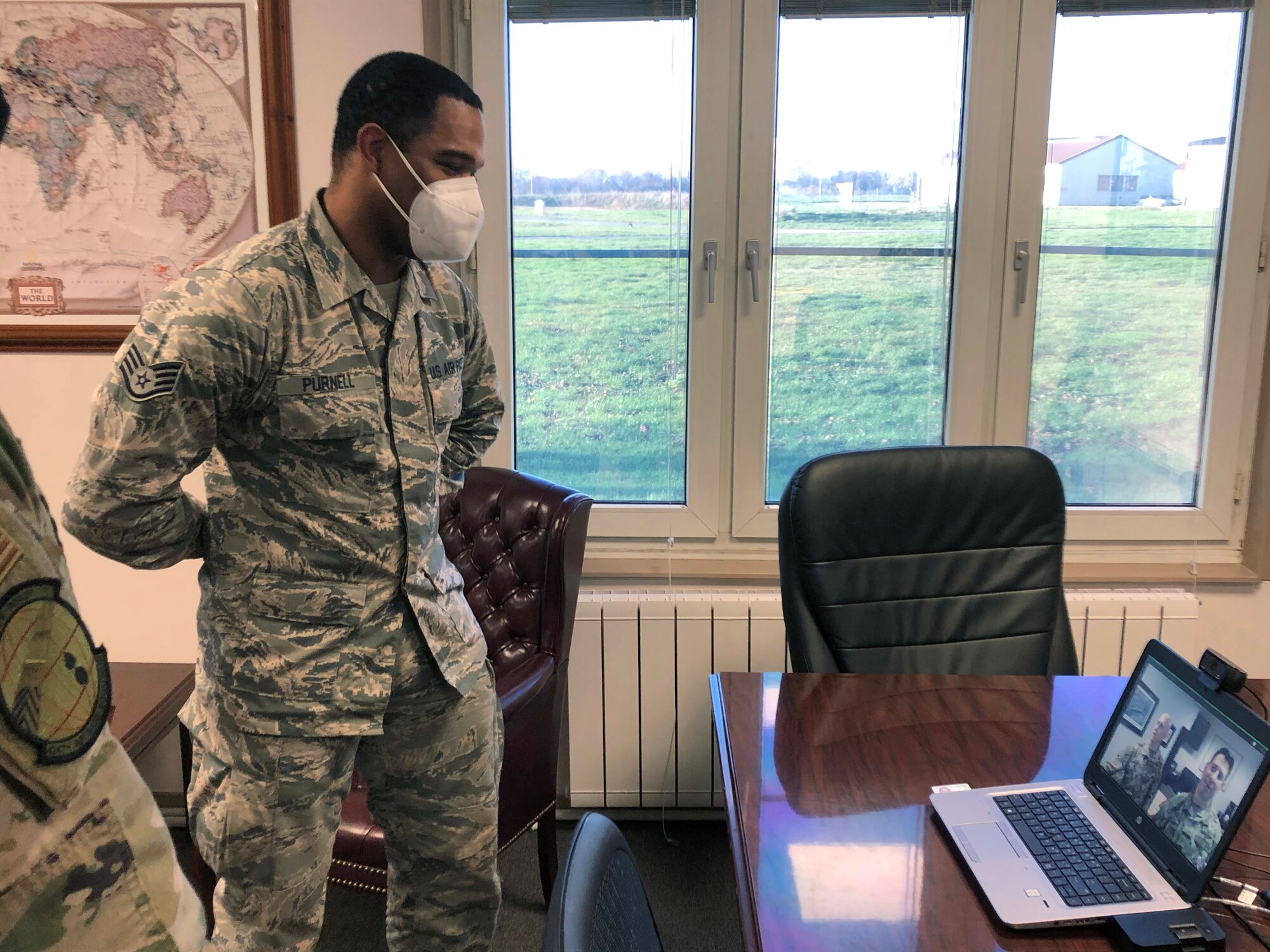 Airman standing in front of a laptop computer.