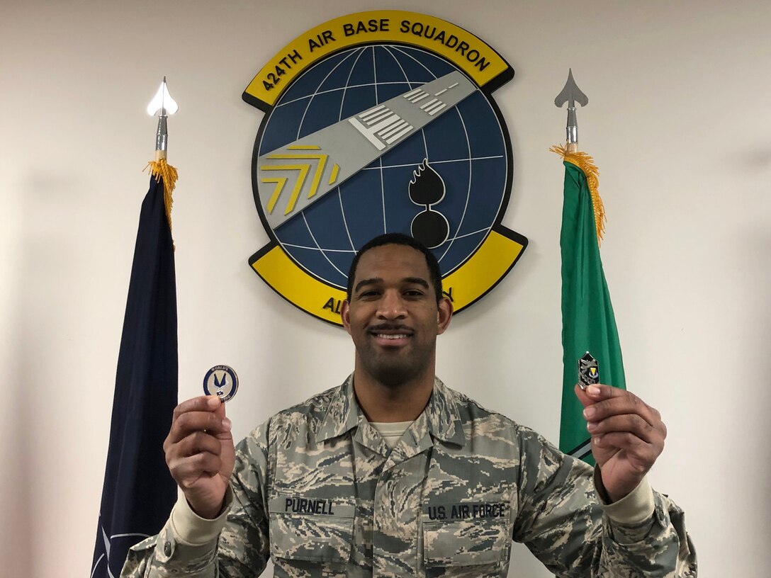 Airman holding two coins.