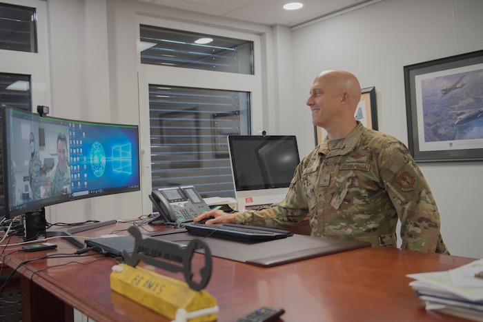 Commander standing at desk with computer.