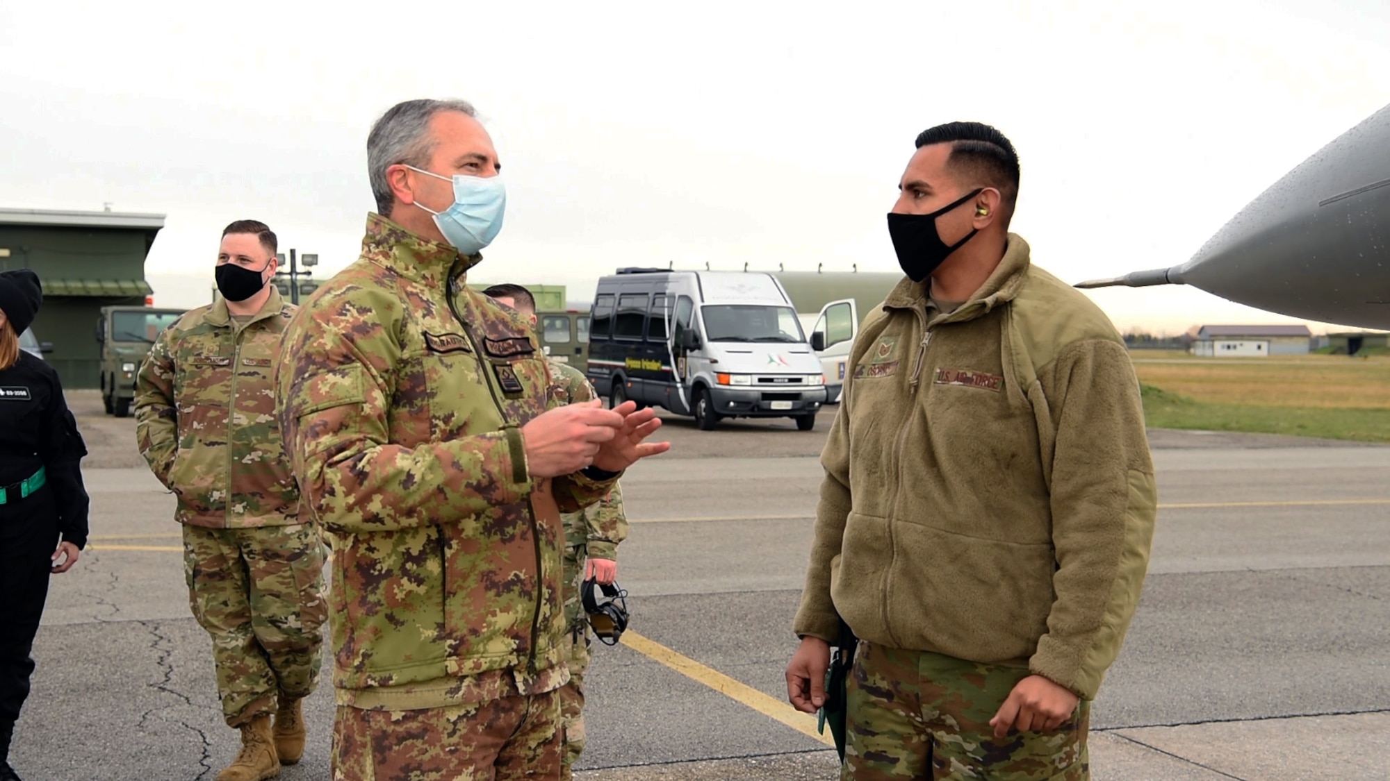 Tech. Sgt. Mario Osorno, 31st Aircraft Maintenance Squadron weapons load crew chief, right, speaks with an Italian air force member at Rivolto Air Base, Italy, Dec. 16, 2020. U.S. and Italian airmen spoke about the differences between the F-16 A and B models, which the Italians had experience with, and the C and D models, which are used by the 31st Fighter Wing today. (U.S. Air Force photo by Staff Sgt. Heidi Goodsell)