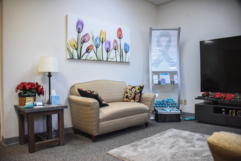 A large common area with new furniture, stress balls and floral décor.