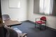 A picture of a small room with two grey chairs and one red chair.