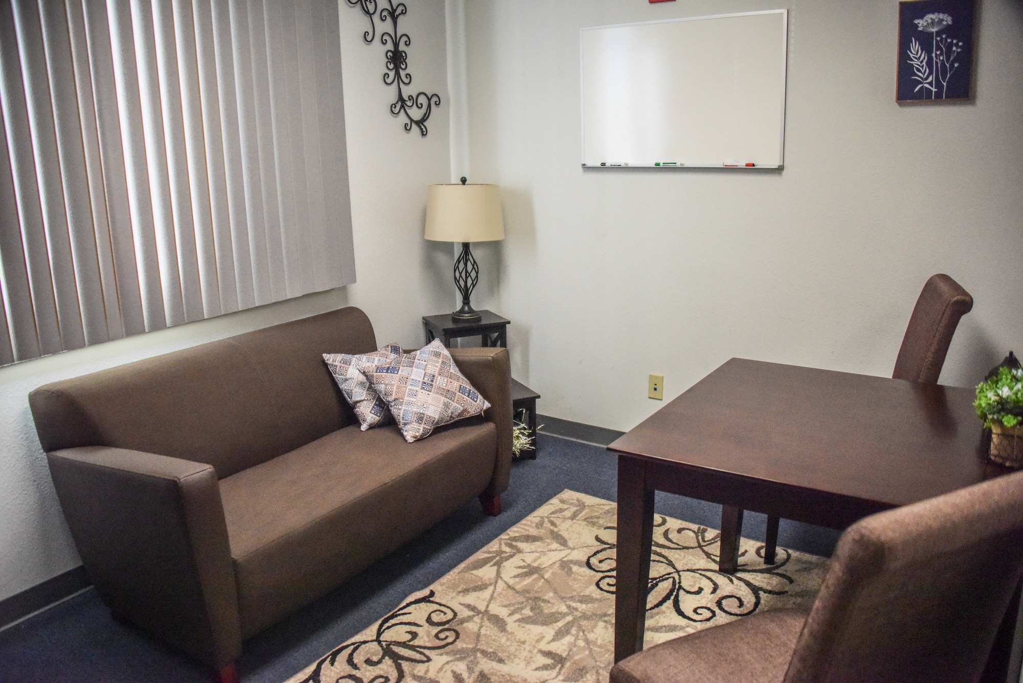 A picture of a small room with brand new furniture and carpet.
