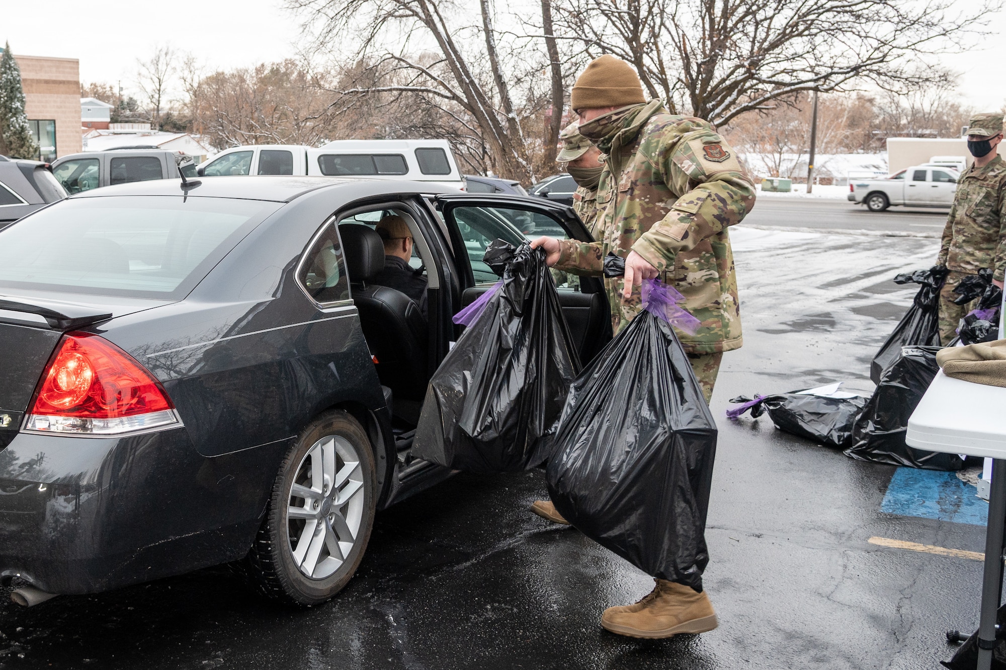 Senior Airman Ben Little, 419th Fighter Wing, loads bags of wrapped gifts into a volunteer's car at Utah Foster Care Foundation in Ogden, Utah, Dec. 17, 2020, as part of a volunteer effort called Santa Brigade