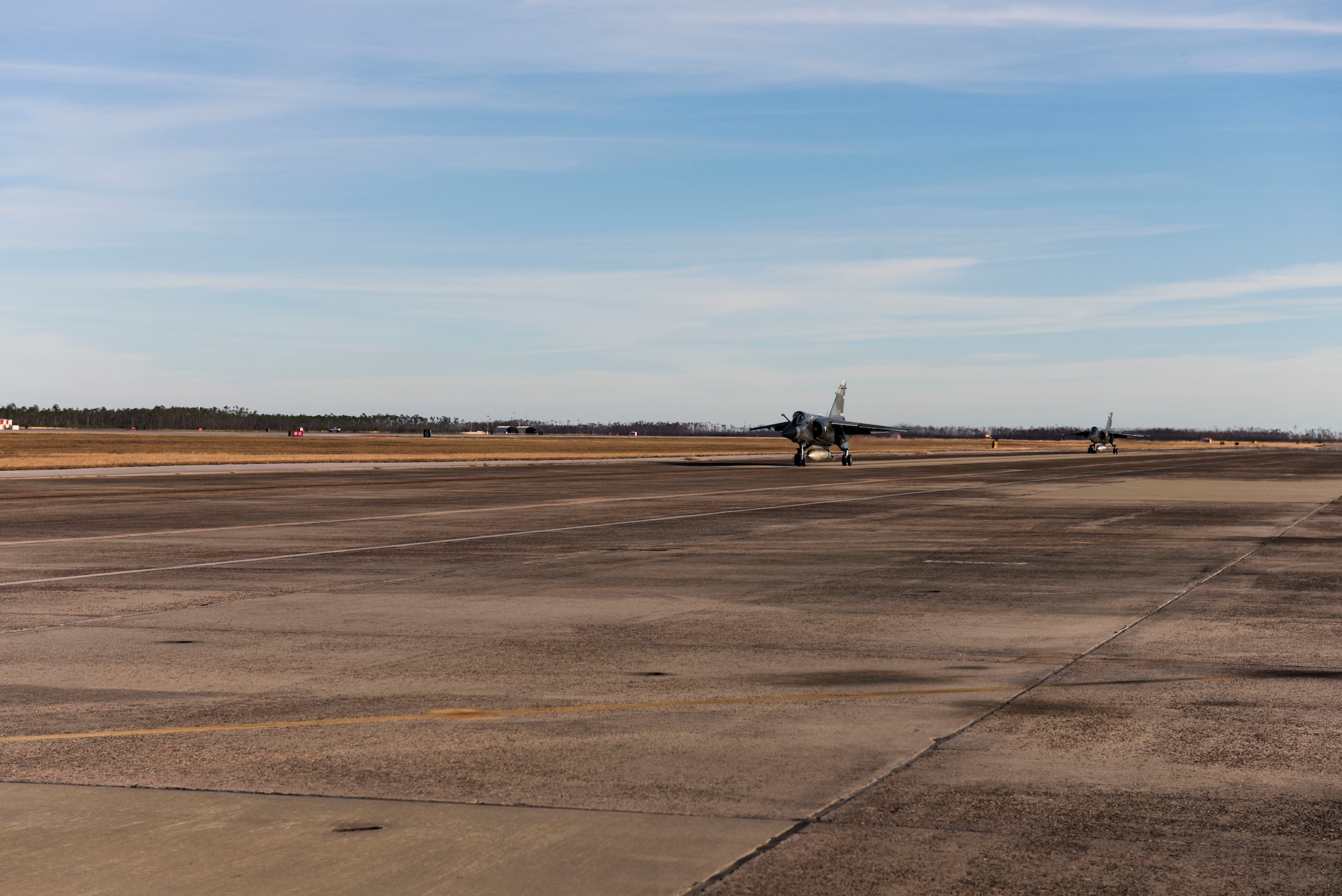 Two airplanes taxi down a runway