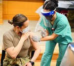 Senior Airman Marisol Salgado (right), medical technician, administers a Pfizer-BioNTech COVID-19 vaccine to Army Capt. Rebecca Parrish, a COVID-19 intensive care unit nurse Dec. 17 at Brooke Army Medical Center at Joint Base San Antonio-Fort Sam Houston. Parrish was the first BAMC staff member to receive a COVID-19 vaccine.