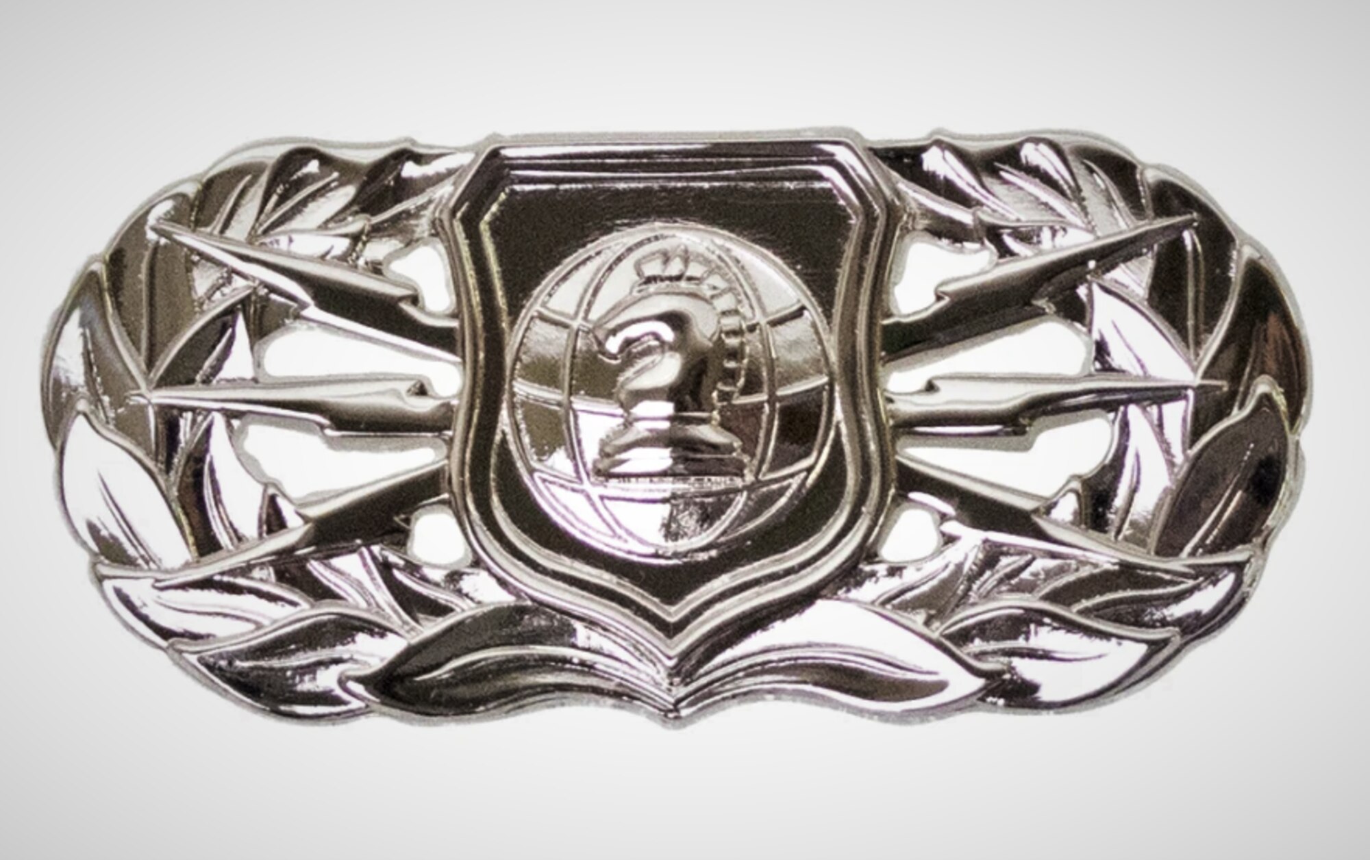 A silver badge shaped like a sphere with a chess piece in the center and lightning bolts on each side.