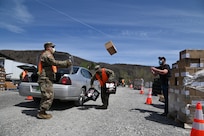 Vermont National Guard Soldiers and state partners load meals into vehicles in a parking lot in Peru, Vermont, May 19, 2020. The Vermont National Guard helps the Vermont Food Bank "Farmers to Families" program and Vermont Emergency Management deliver fresh produce, dairy and prepared meals. (U.S. Air National Guard photo by Tech. Sgt. Garth Dunkel)