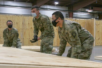 Soldiers and Airmen assigned to the Vermont National Guard's COVID-19 response reconstruct the Alternate Healthcare Facility at the Champlain Valley Fairgrounds in Essex Junction, Vermont, Nov. 19, 2020. The AHF was originally constructed in April, but was disassembled in July after seeing little use. The Vermont National Guard is reusing the materials from the earlier project to construct this smaller facility, which will remain locked until the the Vermont Department of Health determines it is needed. It can accommodate up to 200 patients if needed.