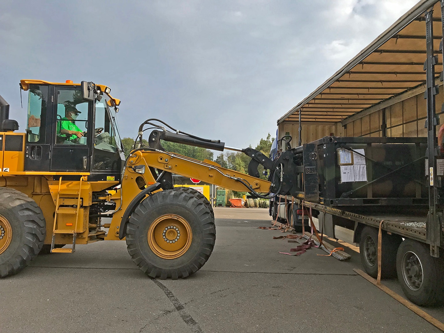 A material handling machine unloads an item from a truck.