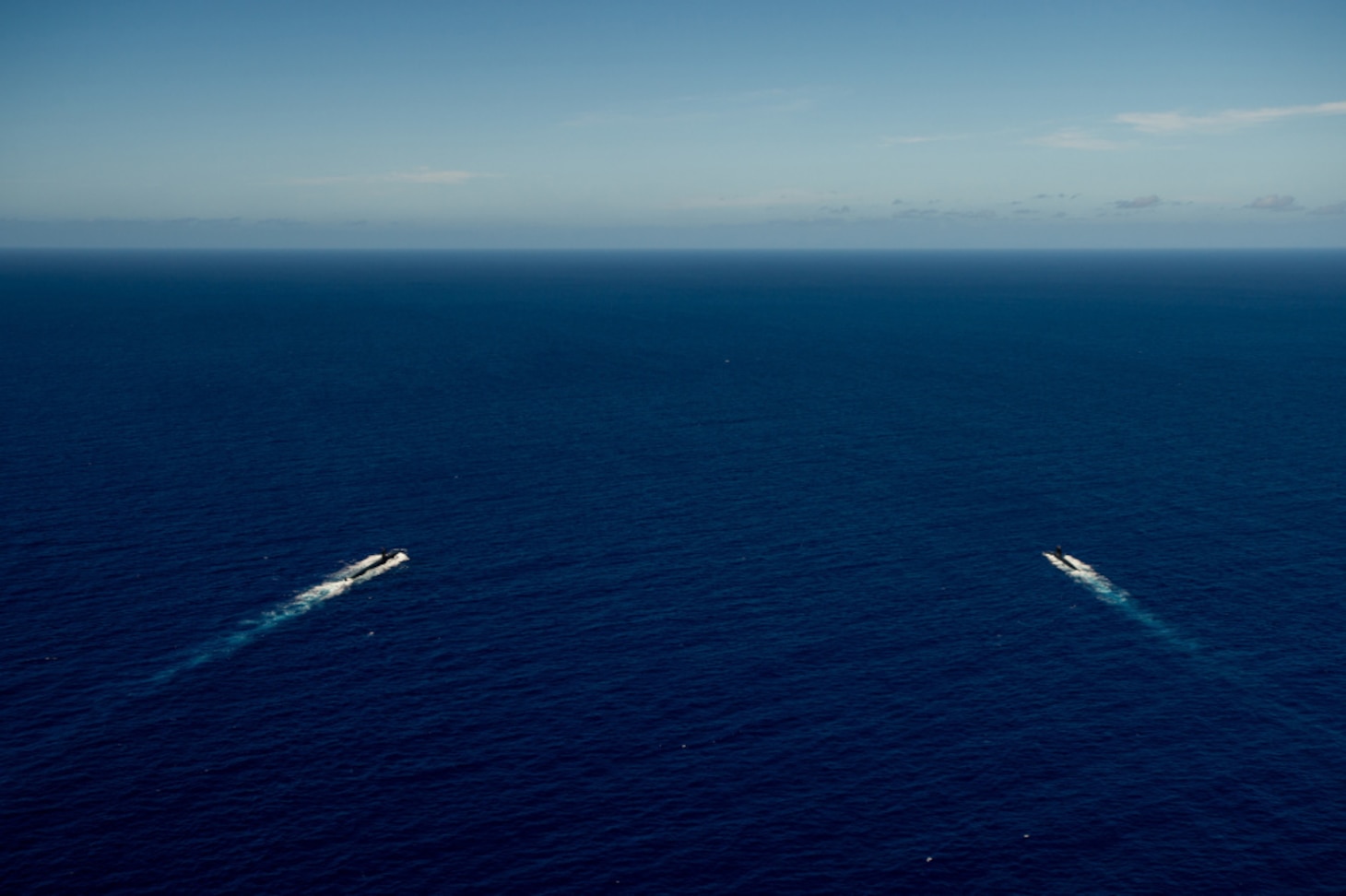 WATERS OFF GUAM (Dec. 11, 2020) The Los Angeles-class fast-attack submarine USS Asheville (SSN 758), left, and the French Navy Rubis-class nuclear powered submarine (SSN) Émeraude steam in formation off the coast of Guam during a photo exercise. Asheville and Émeraude practiced high-end maritime skills in a multitude of disciplines designed to enhance interoperability between maritime forces. Asheville is one of four forward-deployed submarines assigned to Commander, Submarine Squadron 15.