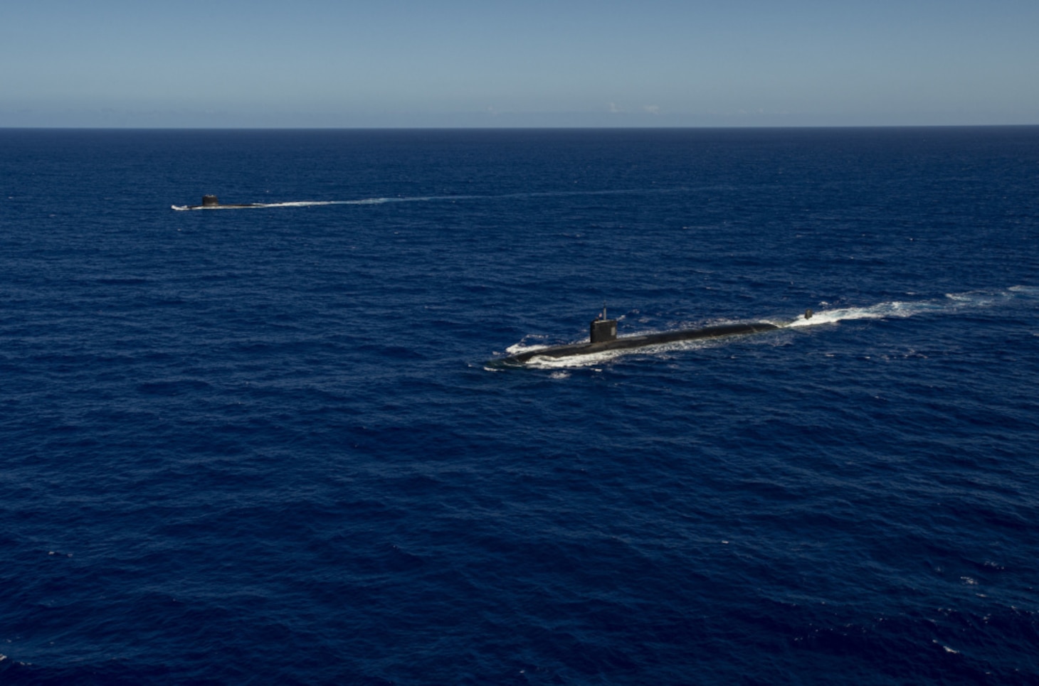 WATERS OFF GUAM (Dec. 11, 2020) The Los Angeles-class fast-attack submarine USS Asheville (SSN 758), right, and the French Navy Rubis-class nuclear powered submarine (SSN) Émeraude steam in formation off the coast of Guam during a photo exercise. Asheville and Émeraude practiced high-end maritime skills in a multitude of disciplines designed to enhance interoperability between maritime forces. Asheville is one of four forward-deployed submarines assigned to Commander, Submarine Squadron 15.