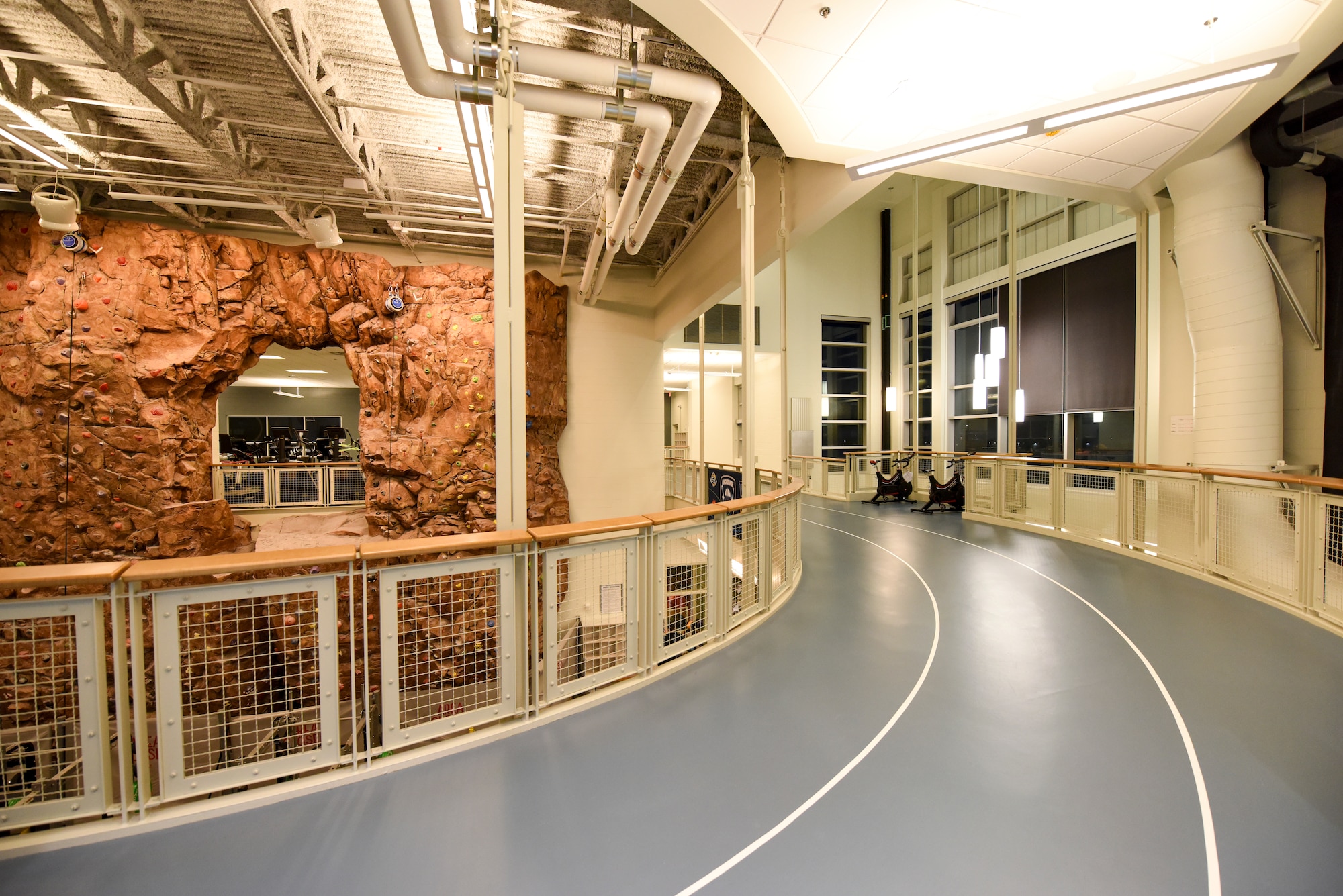 An indoor running track, aerobic machines, free weights and a rock-climbing wall sit ready for use at the Buckner Fitness Center on Joint Base Elmendorf-Richardson, Alaska, Dec 14, 2020. In addition to the 35,000 square-foot state-of-the-art fitness area, Buckner also includes an aquatic center, fitness pool, and an abundance of new strength and cardio machines. (U.S. Air Force photo by Senior Airman Crystal A. Jenkins)