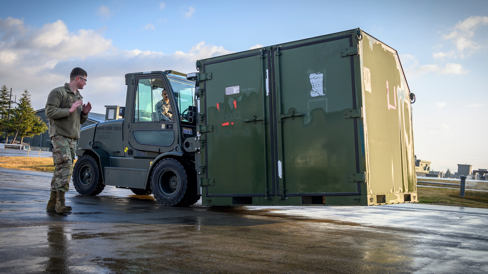 U.S. Air Force Nicholas Covey, a 35th Aircraft Maintenance Squadron support technician, directs Senior Airman Russiel Huertas Muniz, a 35th AMXS crew chief as he relocates cargo during Agile Combat Employment (ACE) week at Misawa Air Base, Japan, Dec. 6, 2020. Utilizing the Multi-Capable Airmen concept in combination with ACE deployments, the U.S. Air Force can maintain mission capability with fewer deployed Airmen. (U.S. Air Force photo by Airman 1st Class China M. Shock)