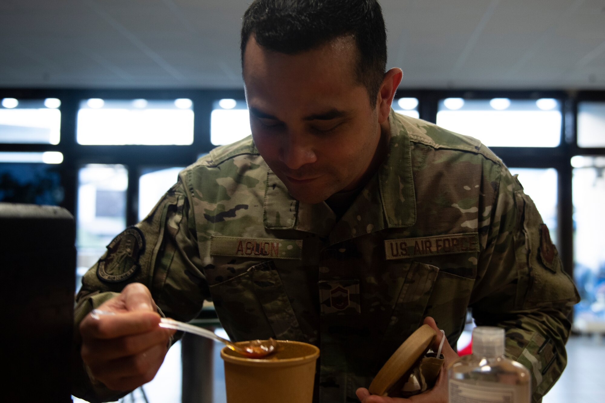 A photo of an Airman preparing to eat soup.