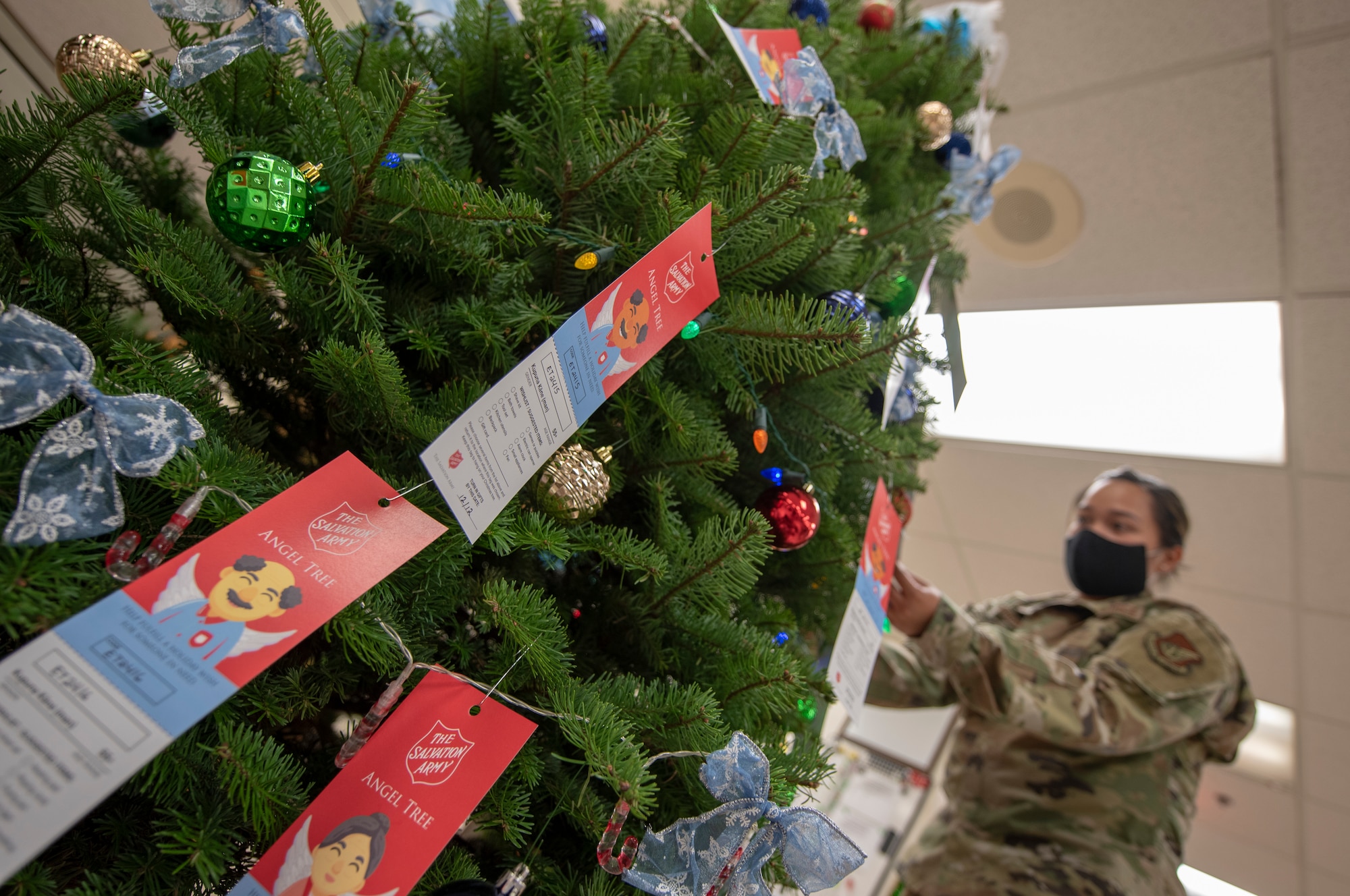 Senior Airman Kathyrn Bayudan, material management specialist with the 154th Logistics Readiness Squadron adjusts ornaments and Angel Tree tags on her unit’s ‘Angel Tree’ Christmas tree, Dec. 5, 2020, Joint Base Pearl Harbor-Hickam. The Angel Tree is a charitable program that collects donations to fulfill christmas wishlists for elderly and children in need. Through the program, Bayudan and fellow LRS Airmen have collected donations to fulfill more than 80 separate christmas wishlists for the Salvation Army sponsored project. (U.S. Air National Guard photo by Staff Sgt. Orlando Corpuz)