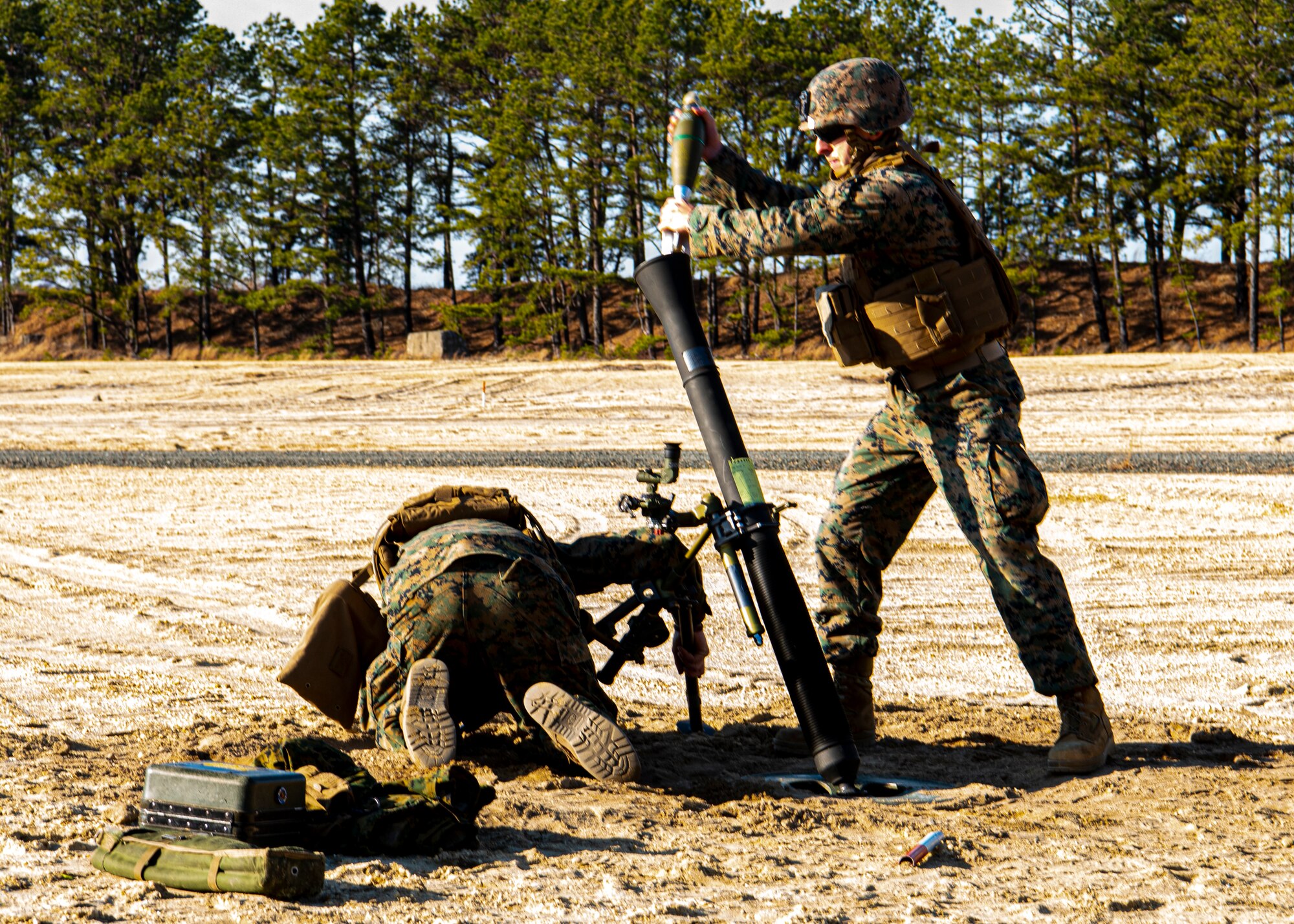Marines load a round into a mortar system.