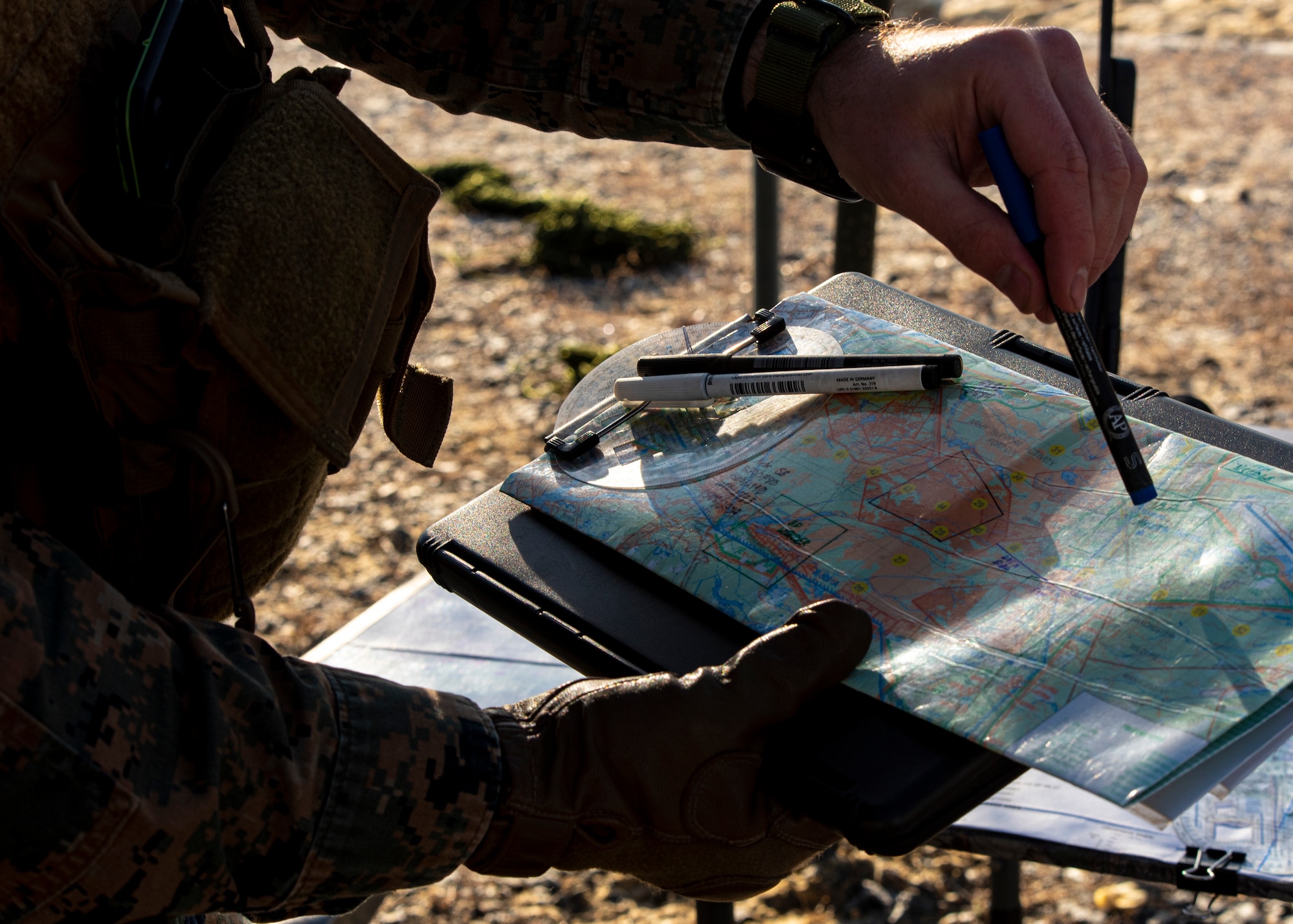 A marine points to a target on a map.