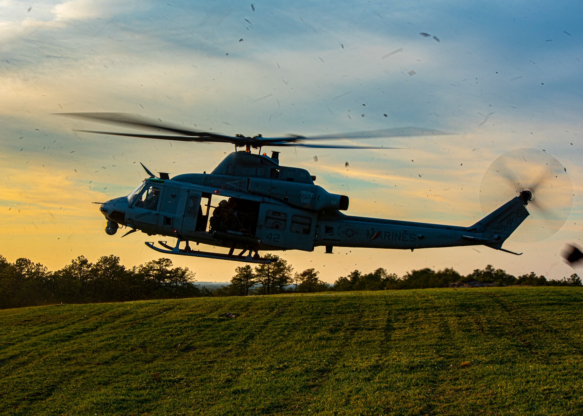 A helicopter hovers over the ground.