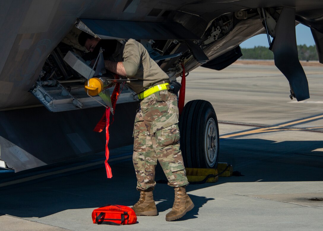man secures missile on plane